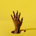 persons hand on yellow surface