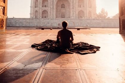 person sitting in front of the taj mahal