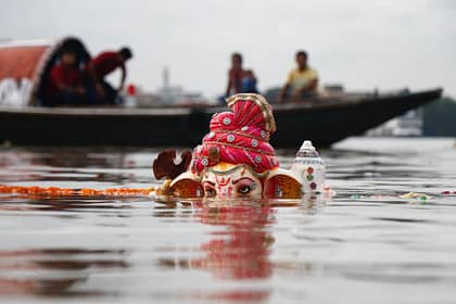 lord ganesha statuette submerged on body of water